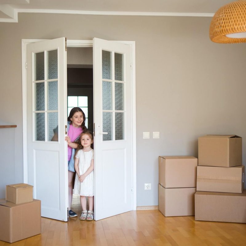 children-look-into-its-new-home-moving-to-apartment-boxes-in-house-1-1.jpg